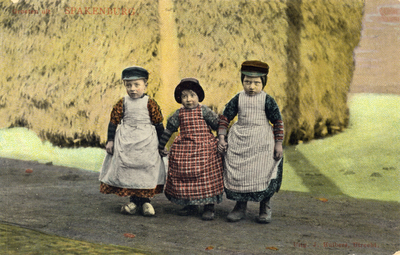 8944 Groepsportret van drie kinderen in klederdracht bij een hooiberg te Spakenburg.